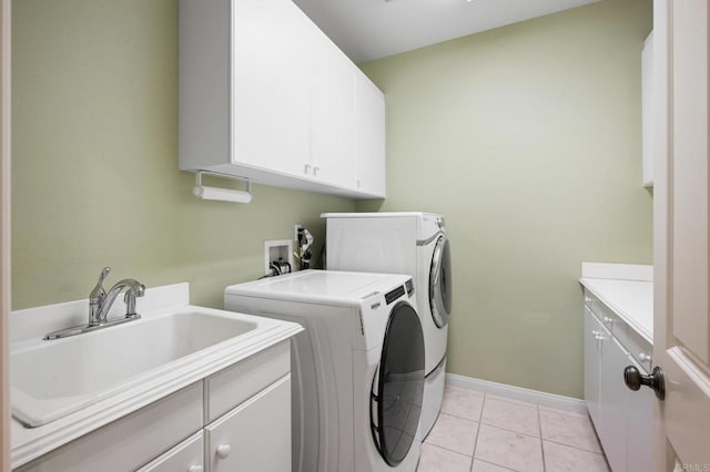 washroom featuring cabinets, light tile patterned floors, sink, and washing machine and clothes dryer