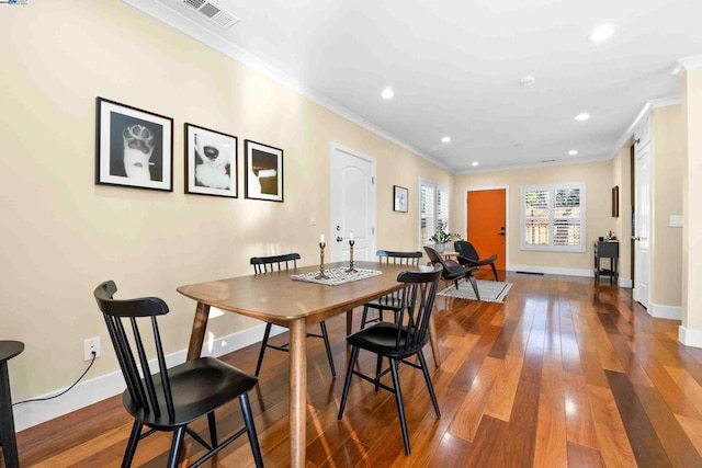 dining space featuring crown molding and hardwood / wood-style flooring