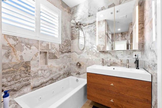 bathroom with vanity, a bathing tub, tile patterned flooring, and tile walls