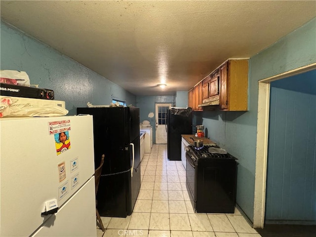 kitchen with black appliances, a textured ceiling, and light tile patterned floors