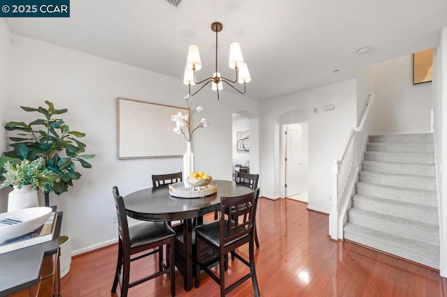 dining space featuring a notable chandelier and dark hardwood / wood-style flooring