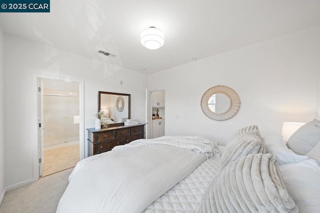 bedroom featuring light colored carpet and ensuite bathroom