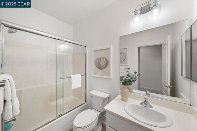 full bathroom featuring enclosed tub / shower combo, vanity, and toilet