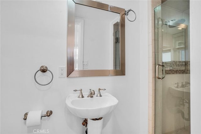 bathroom featuring sink and an enclosed shower