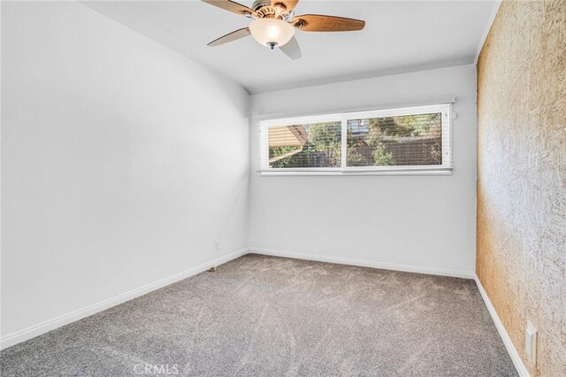 spare room with ceiling fan and carpet