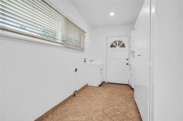 clothes washing area with light tile patterned floors