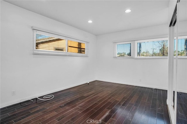 empty room featuring dark wood-type flooring and a wealth of natural light