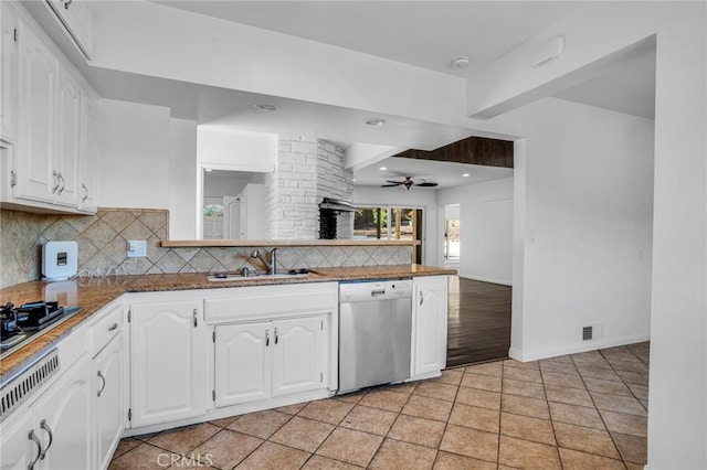 kitchen with kitchen peninsula, appliances with stainless steel finishes, sink, white cabinets, and light tile patterned floors