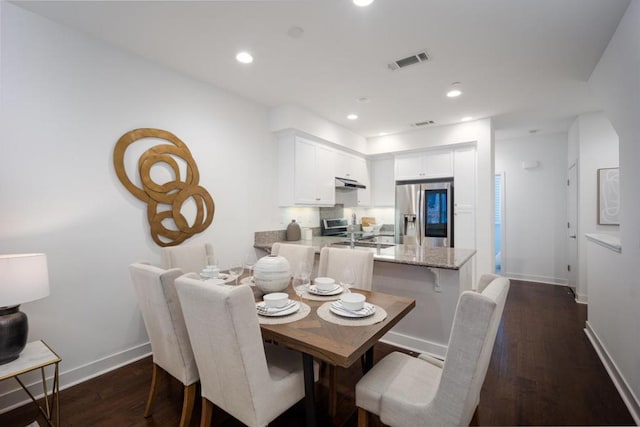 dining area featuring dark wood-type flooring and sink