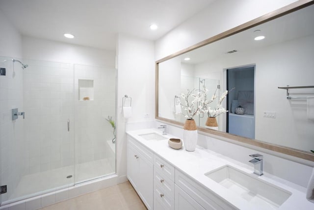 bathroom featuring walk in shower, vanity, and tile patterned flooring