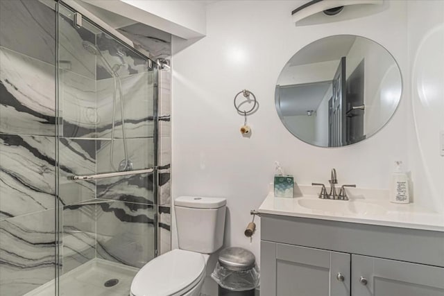 bathroom featuring toilet, an enclosed shower, and vanity