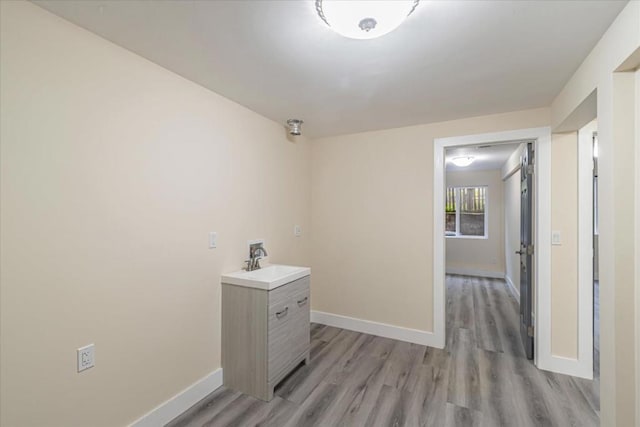 hallway featuring sink and light hardwood / wood-style flooring