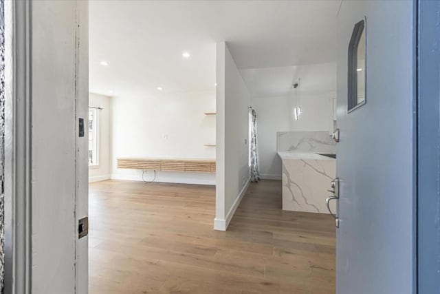 bathroom featuring wood-type flooring, tasteful backsplash, and a healthy amount of sunlight