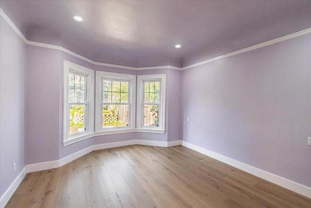 empty room featuring light hardwood / wood-style flooring and ornamental molding