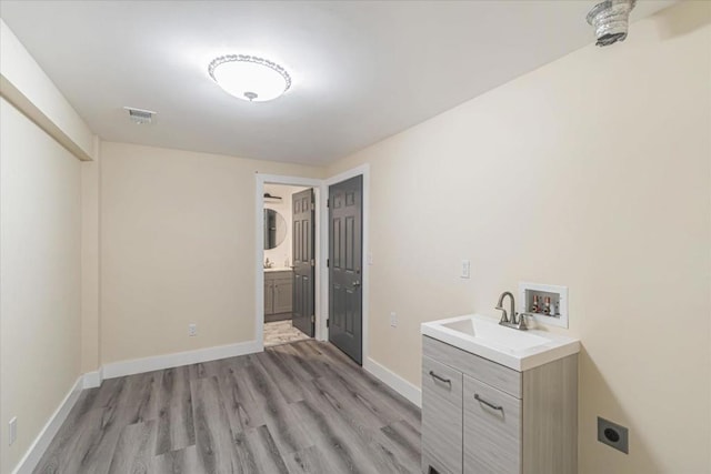 laundry area featuring sink, hookup for a washing machine, hookup for an electric dryer, and light hardwood / wood-style floors