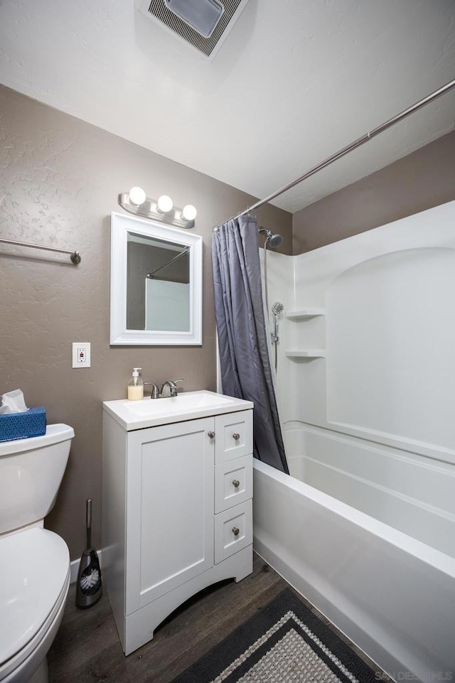 full bathroom featuring hardwood / wood-style flooring, toilet, shower / tub combo with curtain, and vanity