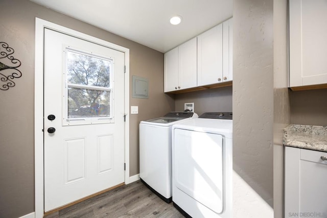 laundry room featuring separate washer and dryer, dark hardwood / wood-style flooring, and cabinets