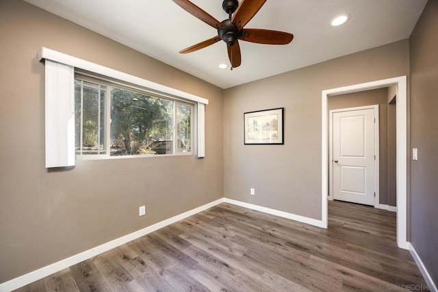 empty room with hardwood / wood-style flooring and ceiling fan