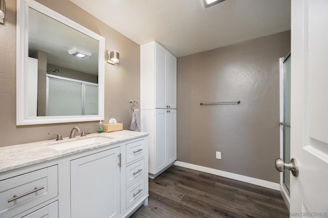 bathroom featuring wood-type flooring, a shower with door, and vanity