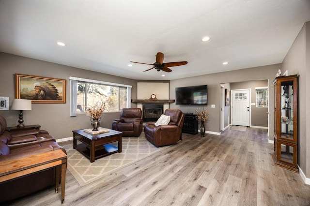 living room featuring ceiling fan and light hardwood / wood-style flooring