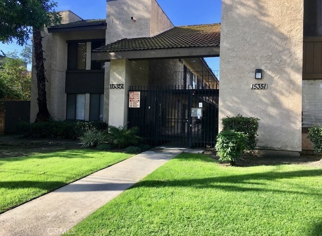 view of gate with a yard