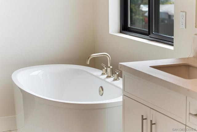 bathroom with a tub and vanity