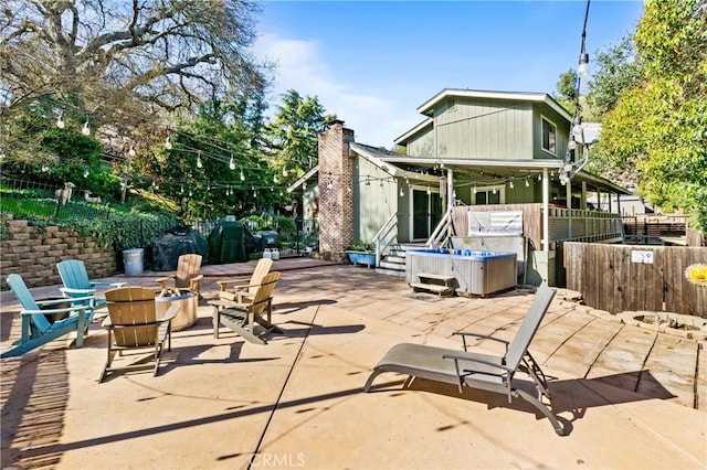 view of patio / terrace featuring an outdoor fire pit and a hot tub