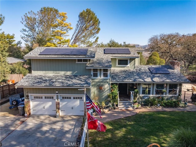 view of front of house with covered porch, a garage, and a front lawn