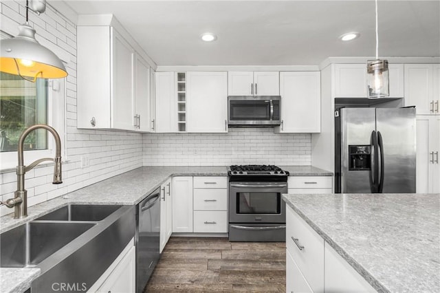 kitchen featuring white cabinetry, dark hardwood / wood-style flooring, stainless steel appliances, decorative backsplash, and sink