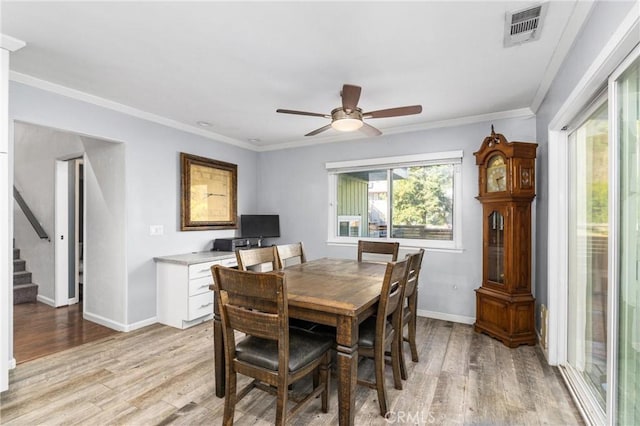 dining area with ceiling fan, crown molding, and light wood-type flooring