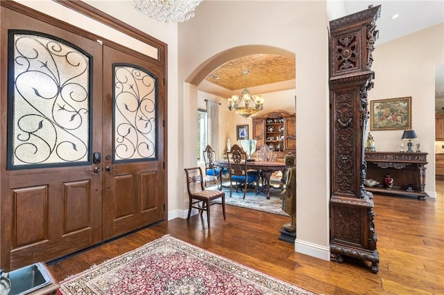 foyer entrance featuring an inviting chandelier and dark hardwood / wood-style flooring