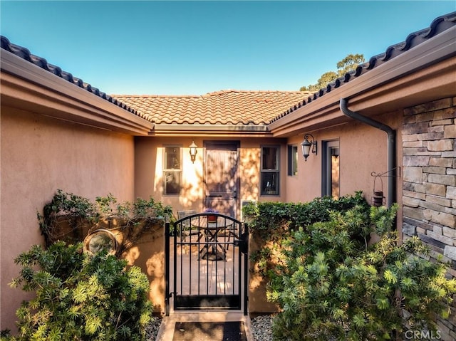 325 Red Oak Way, Arroyo Grande, CA 93420 - view of exterior entry with a gate, a tile roof, and stucco siding