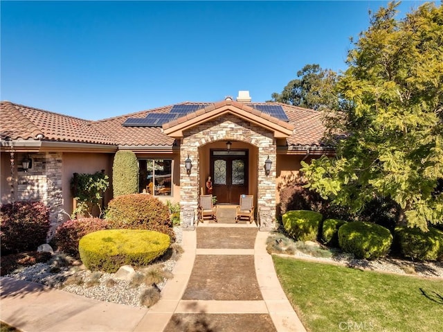 view of front of house featuring a patio area, french doors, and solar panels