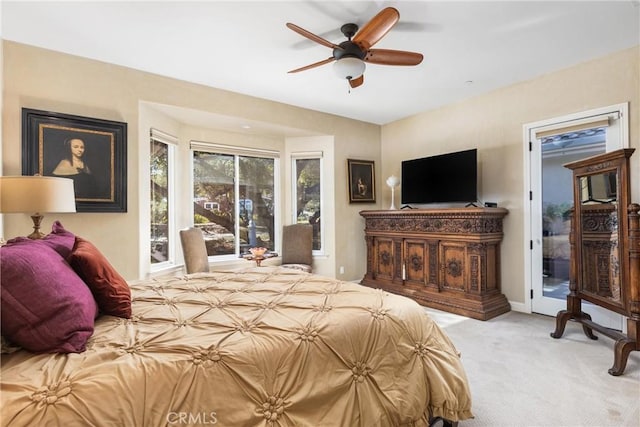 bedroom featuring light carpet, access to exterior, and ceiling fan