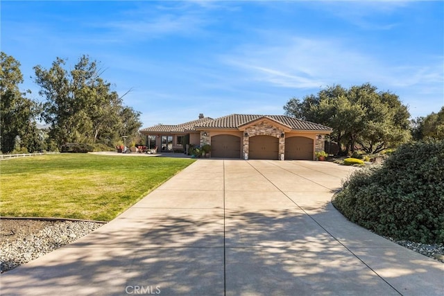 mediterranean / spanish-style house featuring a garage and a front lawn