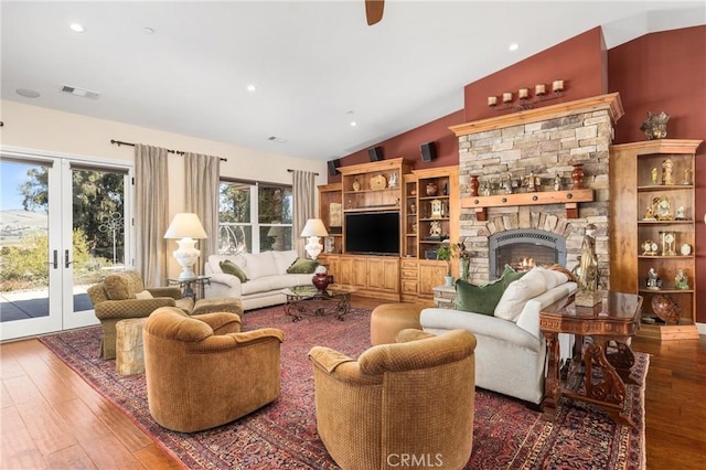 living room with lofted ceiling, hardwood / wood-style floors, and a fireplace