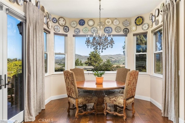 dining room with plenty of natural light, dark wood-type flooring, and a mountain view