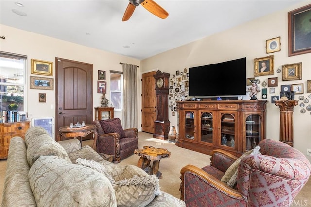 carpeted living room with ceiling fan