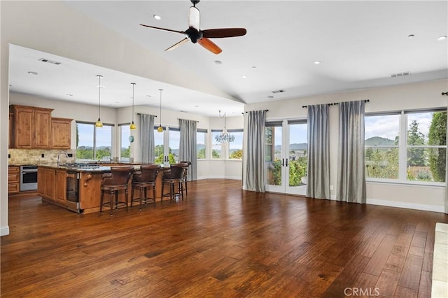 325 Red Oak Way, Arroyo Grande, CA 93420 - kitchen featuring brown cabinets, open floor plan, dark wood finished floors, a kitchen breakfast bar, and a large island with sink