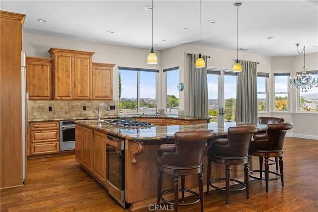 325 Red Oak Way, Arroyo Grande, CA 93420 - kitchen with a spacious island, dark wood-style flooring, decorative backsplash, brown cabinets, and recessed lighting