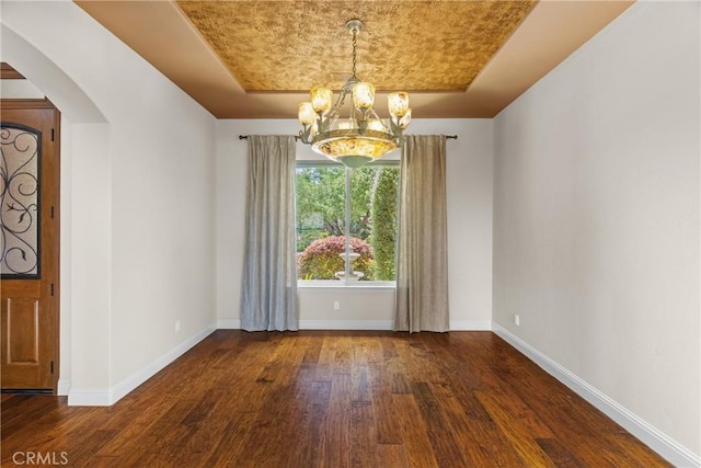 325 Red Oak Way, Arroyo Grande, CA 93420 - spare room featuring a chandelier, wood finished floors, arched walkways, and a raised ceiling