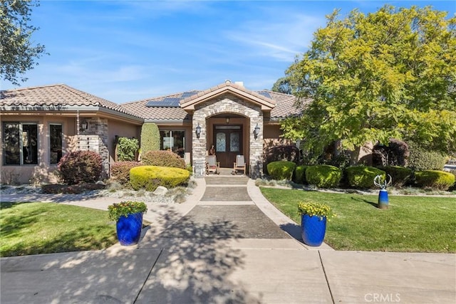 325 Red Oak Way, Arroyo Grande, CA 93420 - view of front facade with stone siding, a front yard, solar panels, a tiled roof, and stucco siding