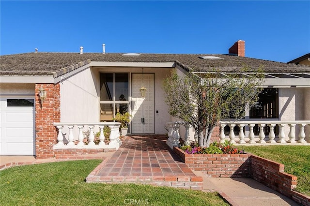 doorway to property with a yard and a garage