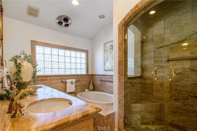 bathroom featuring independent shower and bath, vaulted ceiling, and vanity