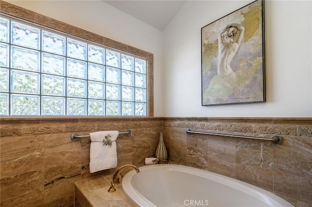 bathroom featuring plenty of natural light and a relaxing tiled tub