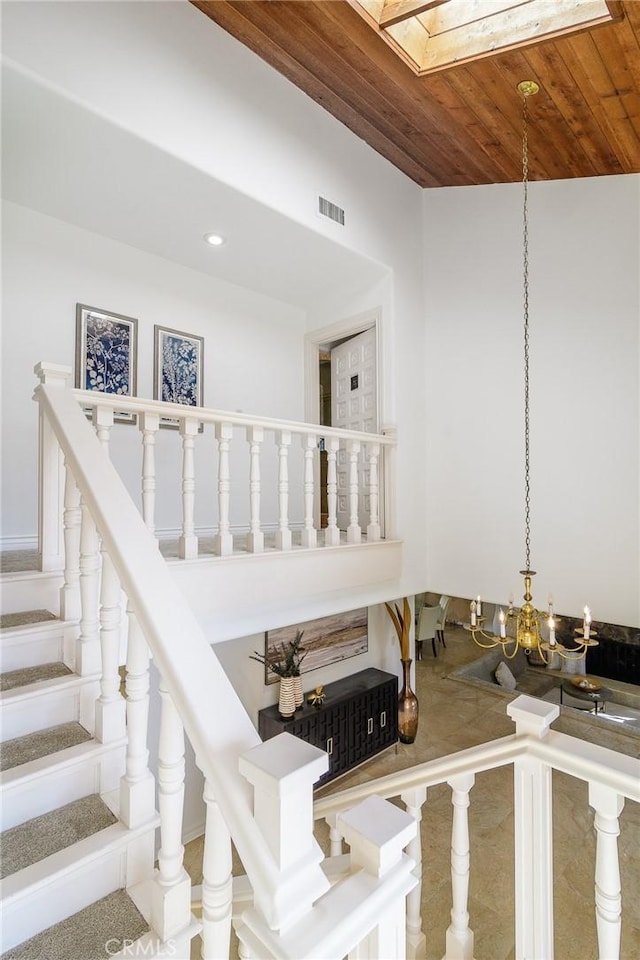 staircase with wood ceiling and a skylight