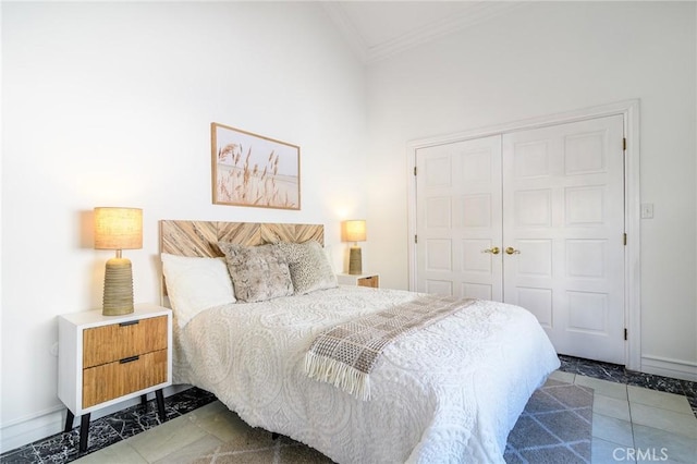 bedroom with crown molding, light tile patterned floors, and a closet