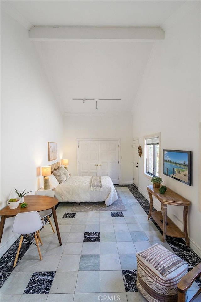 bedroom with beamed ceiling, track lighting, and high vaulted ceiling