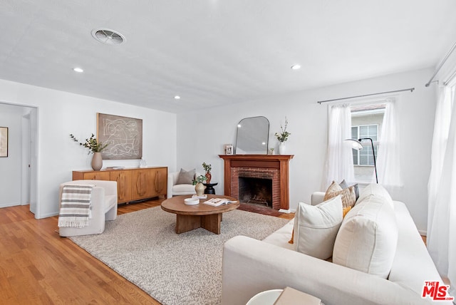 living room with light wood-type flooring and a fireplace