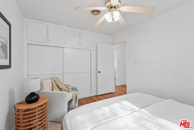 bedroom featuring ceiling fan, light hardwood / wood-style floors, and a closet